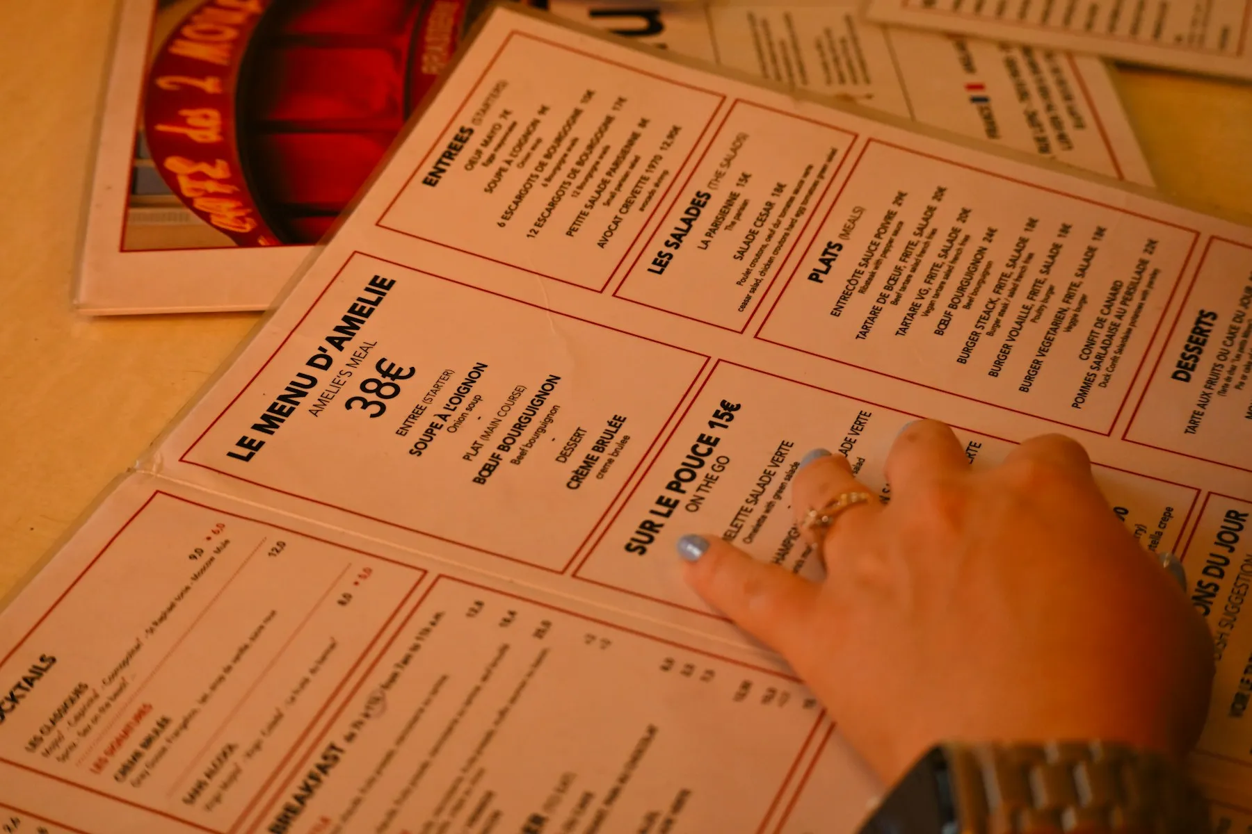 Main posée sur un menu de restaurant imprimé