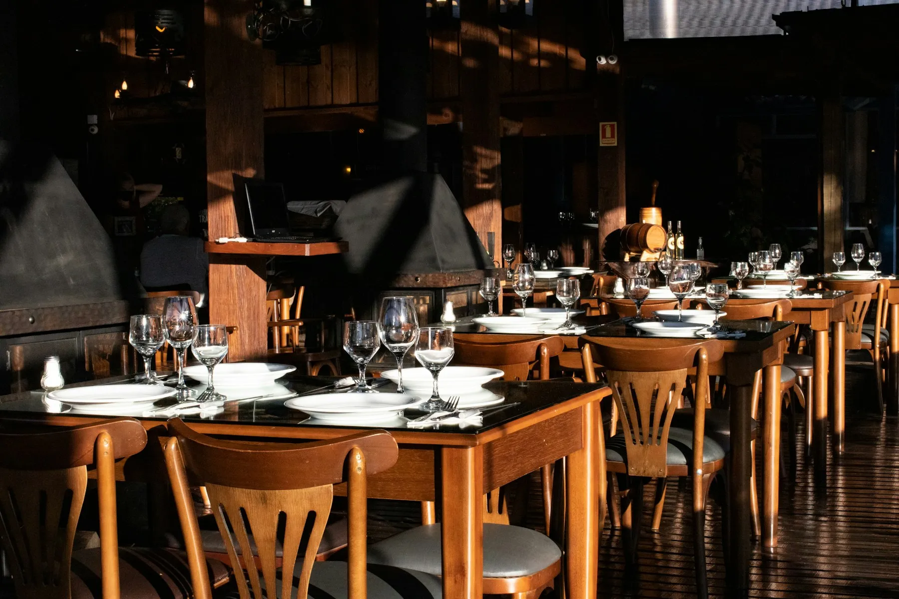 Salle de restaurant chaleureuse aux tables en bois dressées