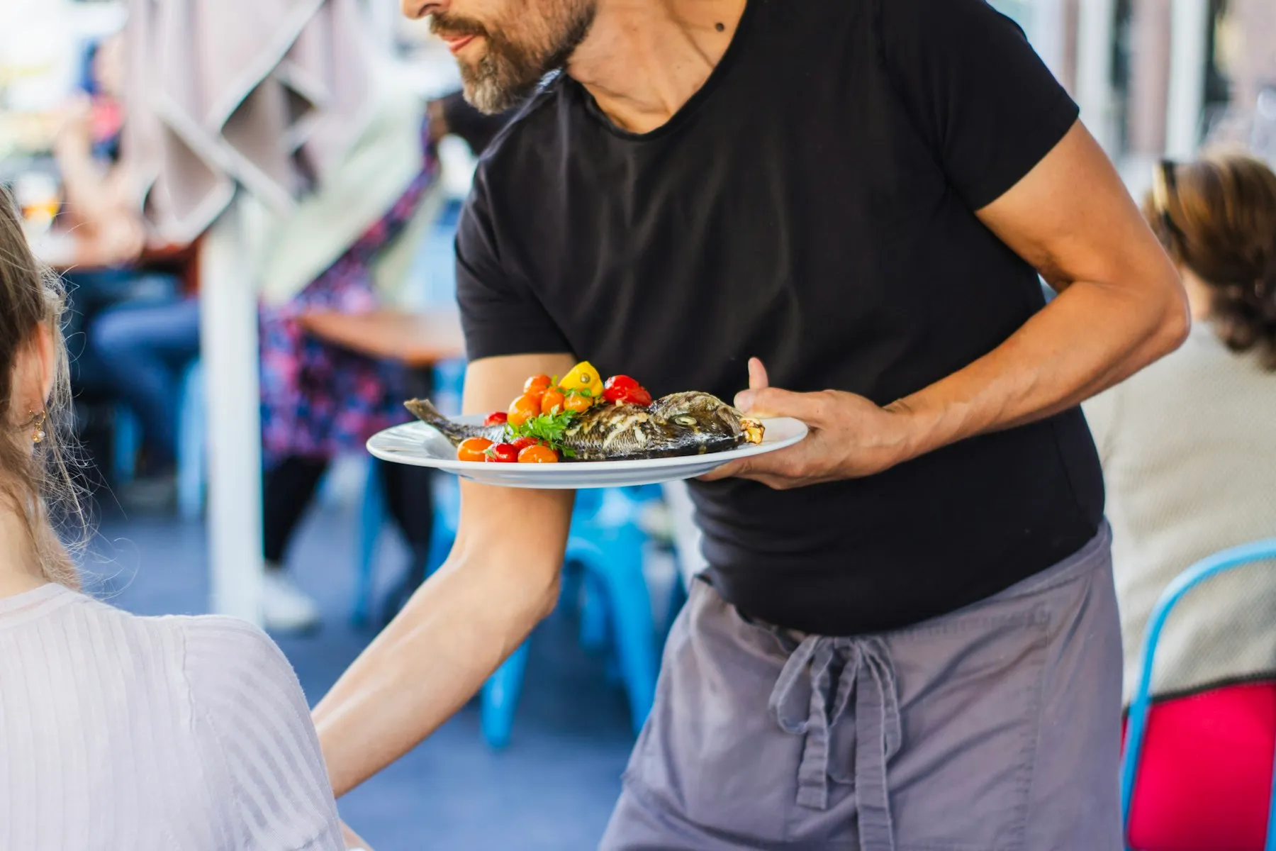 Serveur apportant un plat en terrasse